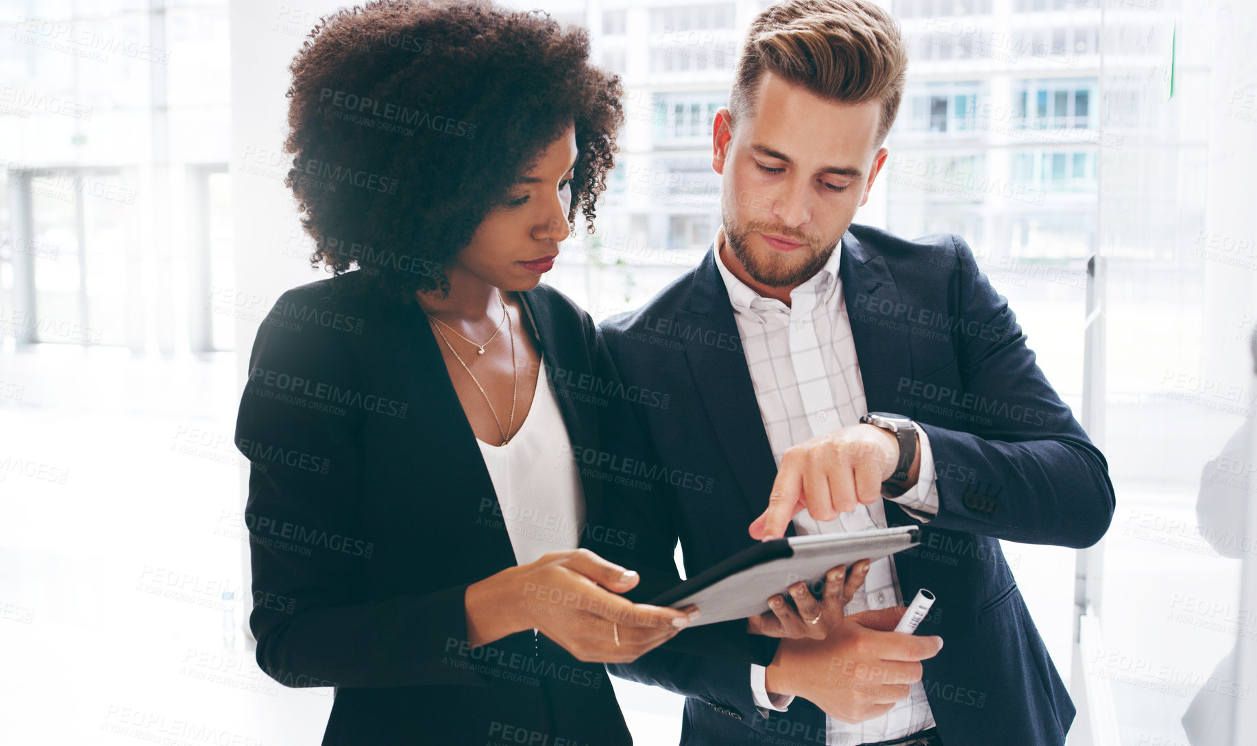 Buy stock photo Shot of a young businessman and businesswoman using a digital tablet during a brainstorming session in a modern office