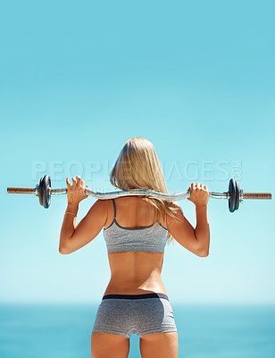 Buy stock photo Rearview shot of a young woman doing squats with a barbell outside