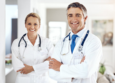 Buy stock photo Cropped portrait of two doctors standing with their arms crossed in the hospital corridor