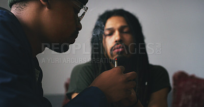 Buy stock photo Shot of two young men smoking a marijuana joint at home