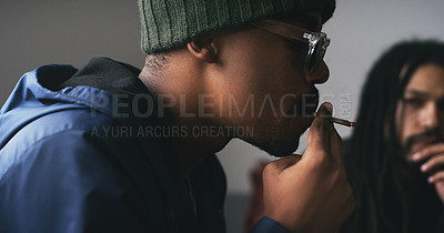 Buy stock photo Shot of two young men smoking a marijuana joint at home