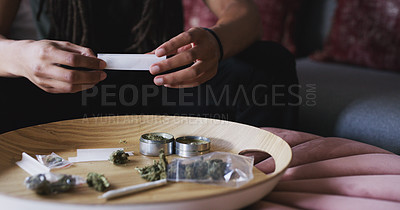 Buy stock photo Cropped shot of a man rolling a marijuana joint at home