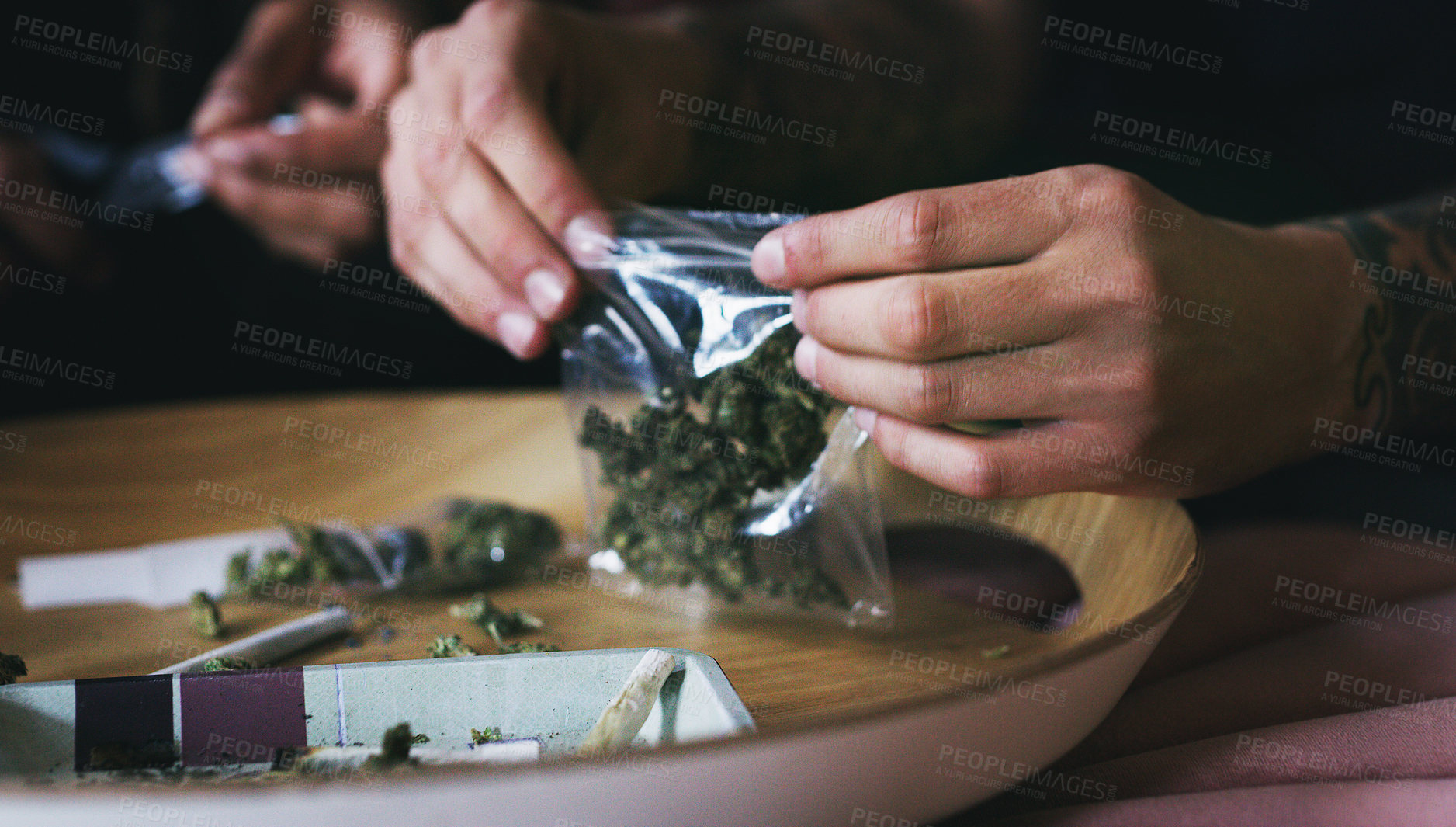 Buy stock photo Cropped shot of a man rolling a marijuana joint at home