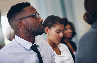 Buy stock photo Cropped shot of a handsome young businessman sitting with his colleagues while in the office during the day