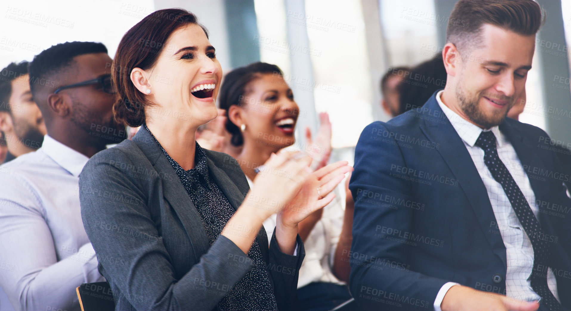 Buy stock photo Cropped shot of an attractive young businesswoman sitting with her colleagues and clapping while in the office during the day