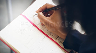 Buy stock photo Cropped shot of an unrecognizable businessperson writing notes in a book while in the office during the day