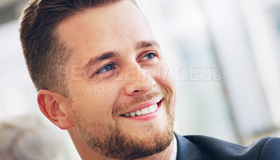 Buy stock photo Cropped shot of a handsome young businessman smiling while looking away in the office during the day