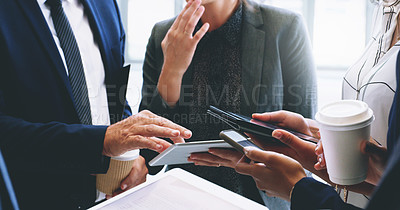 Buy stock photo Cropped shot of an unrecognizable group of businesspeople standing and using technology while in the office