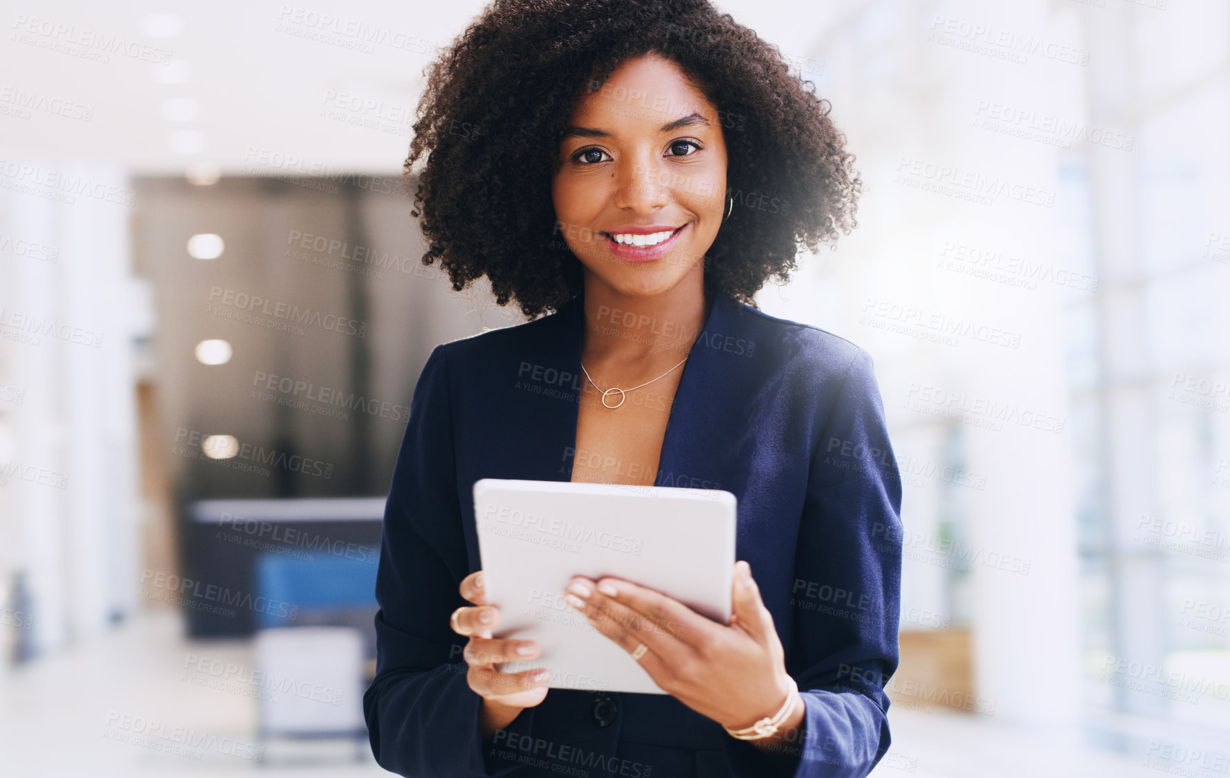 Buy stock photo Cropped portrait of an attractive young businesswoman standing alone and using a tablet while in the office during the day