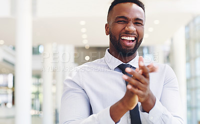 Buy stock photo Cropped portrait of a handsome young businessman standing and clapping while in the office during the day