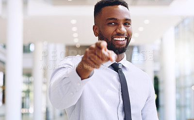 Buy stock photo Cropped portrait of a handsome young businessman standing and pointing while in the office during the day