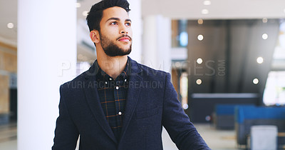 Buy stock photo Cropped shot of a handsome young businessman standing and looking away while in the office during the day