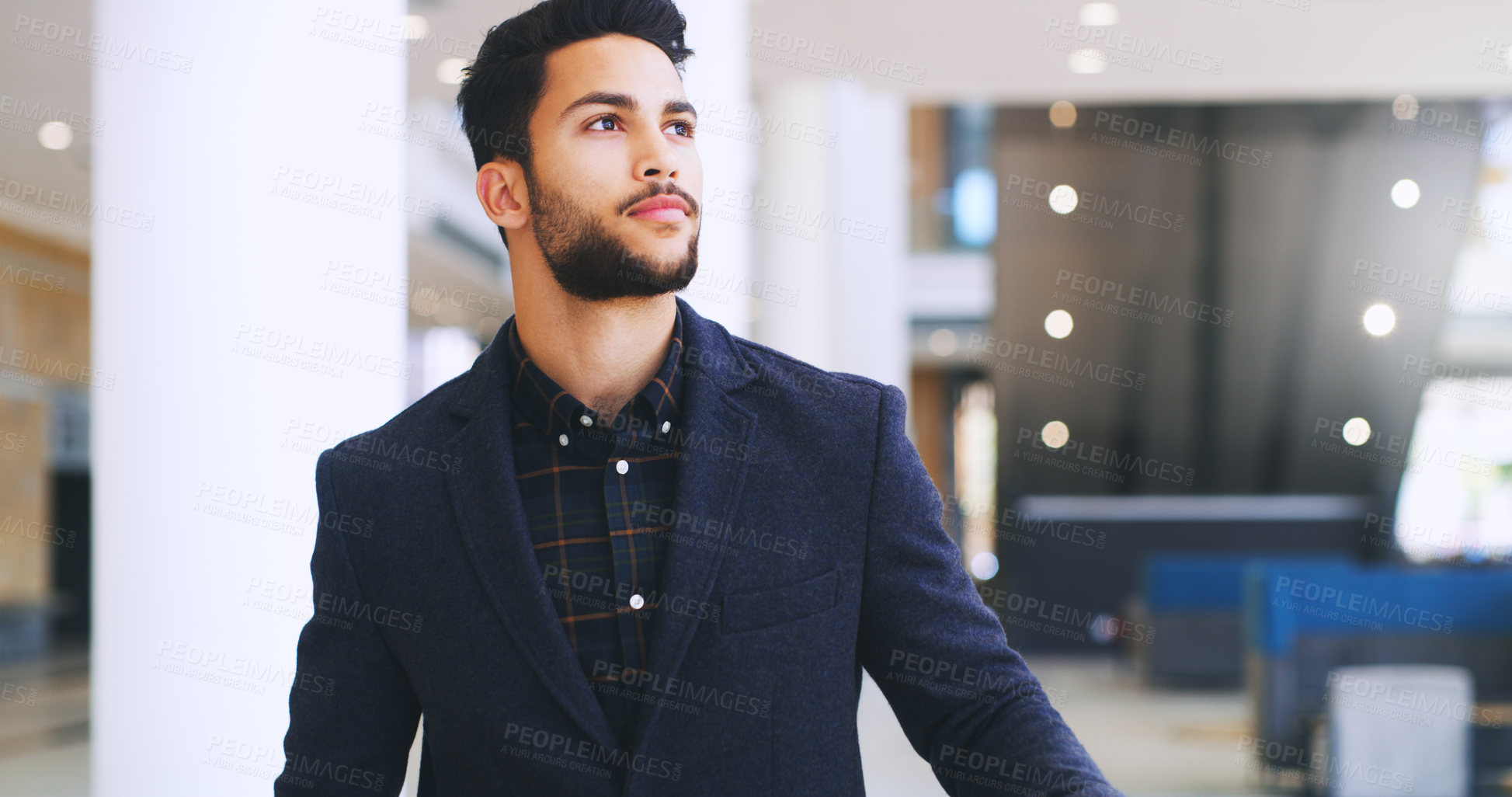 Buy stock photo Cropped shot of a handsome young businessman standing and looking away while in the office during the day