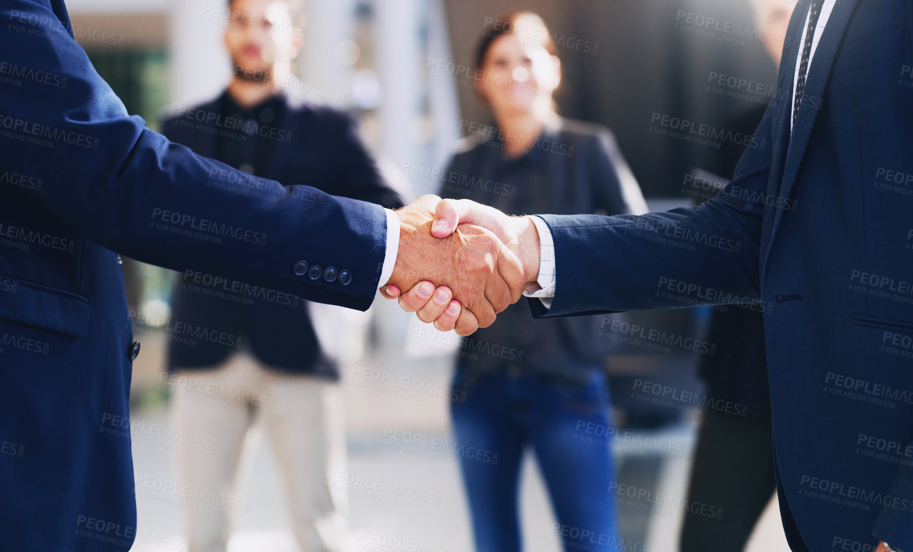 Buy stock photo Cropped shot of two unrecognizable businesspeople shaking hands while in the office during the day