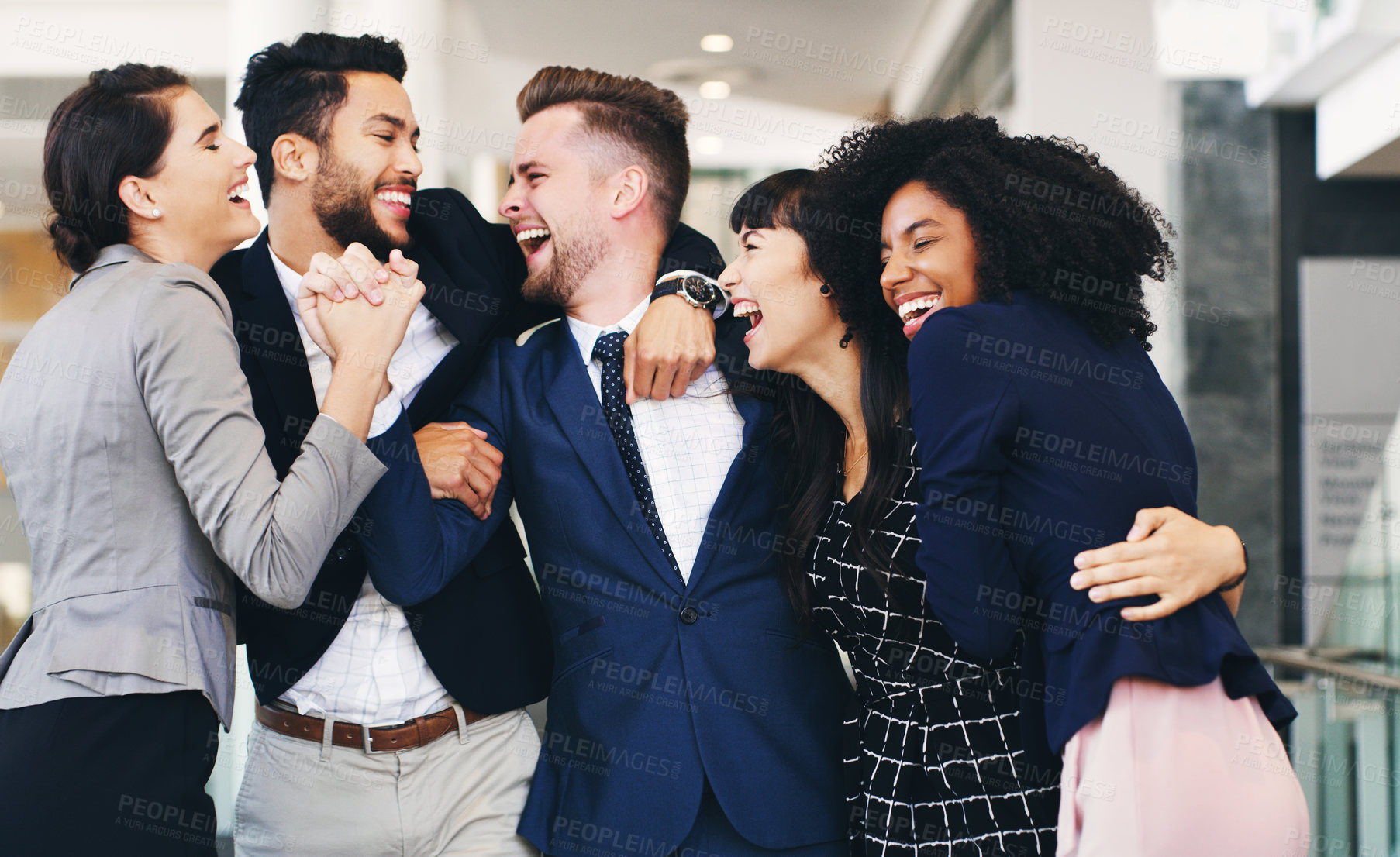 Buy stock photo Cropped shot of a diverse group of businesspeople hugging each other while in the office during the day