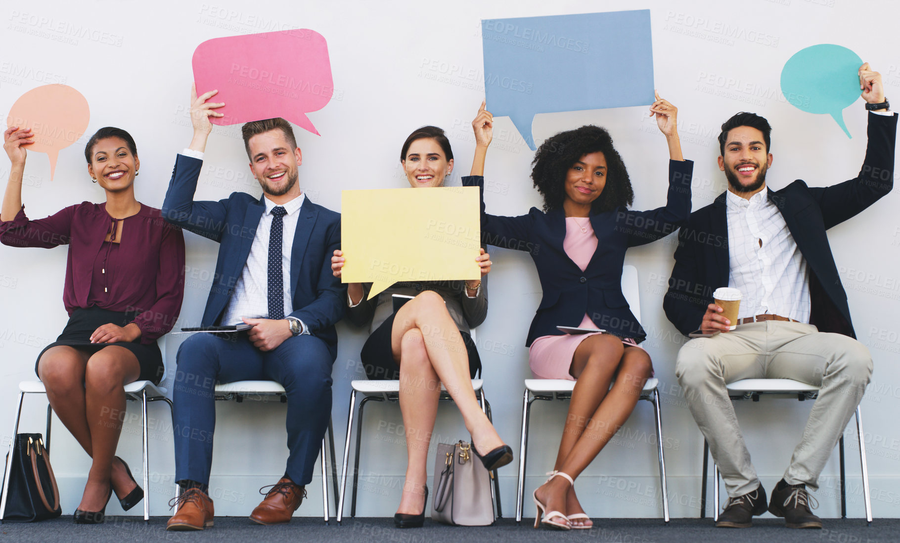 Buy stock photo Full length portrait of a diverse group of businesspeople sitting and holding blank cards while in the office