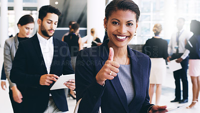 Buy stock photo Cropped portrait of an attractive young businesswoman walking with her colleagues and showing a thumbs up while in the office