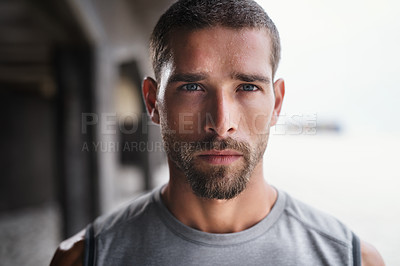 Buy stock photo Portrait of a handsome young sportsman looking serious while exercising outdoors
