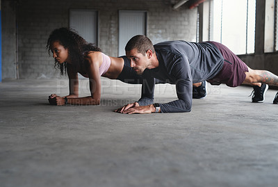 Buy stock photo Full length shot of a sporty young couple exercising together inside an underground parking lot