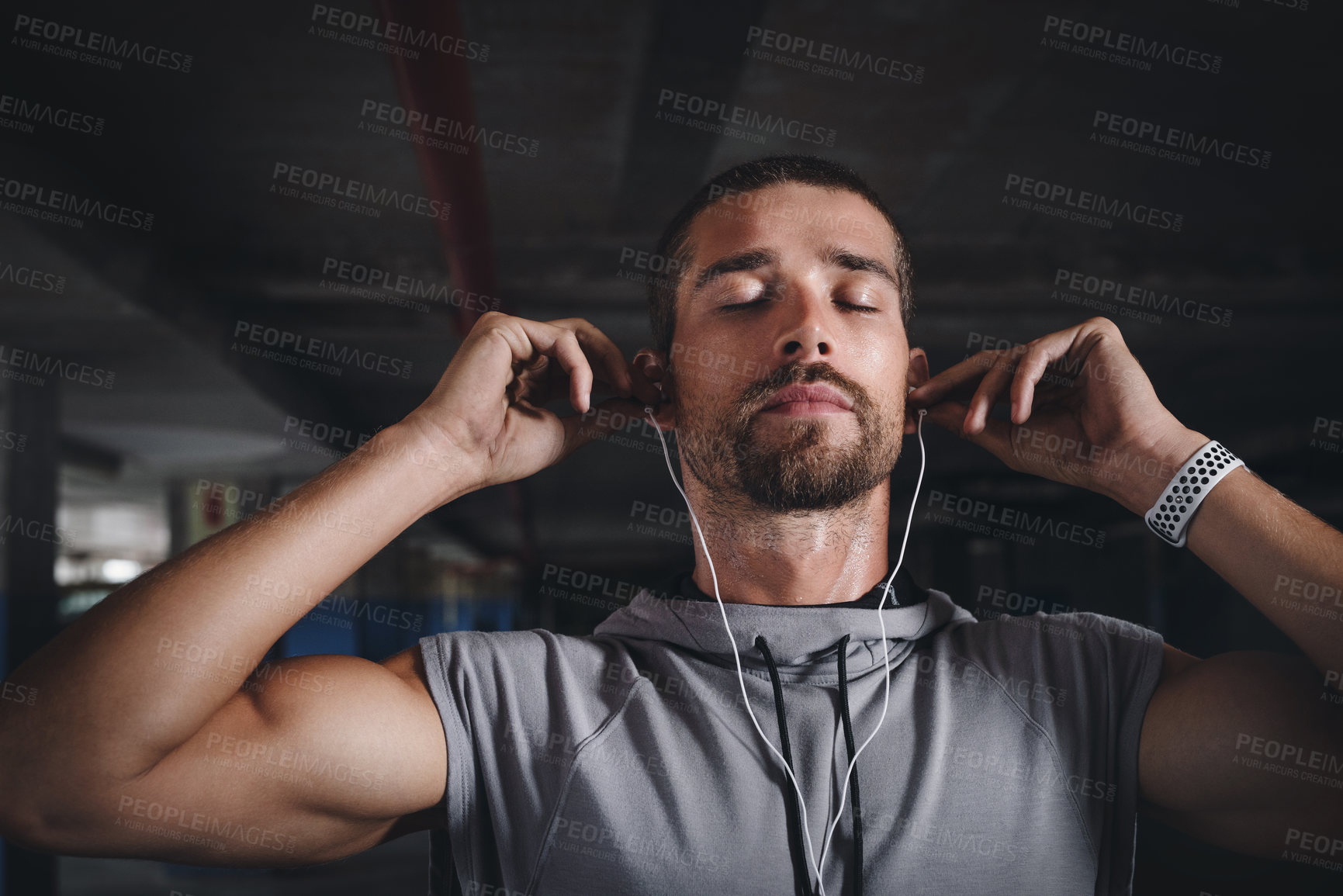 Buy stock photo Fitness, music and face of man in garage for commitment, determination or motivation for sport. Male athlete, earphones or eyes closed in parking lot for workout, thinking or favorite song on radio