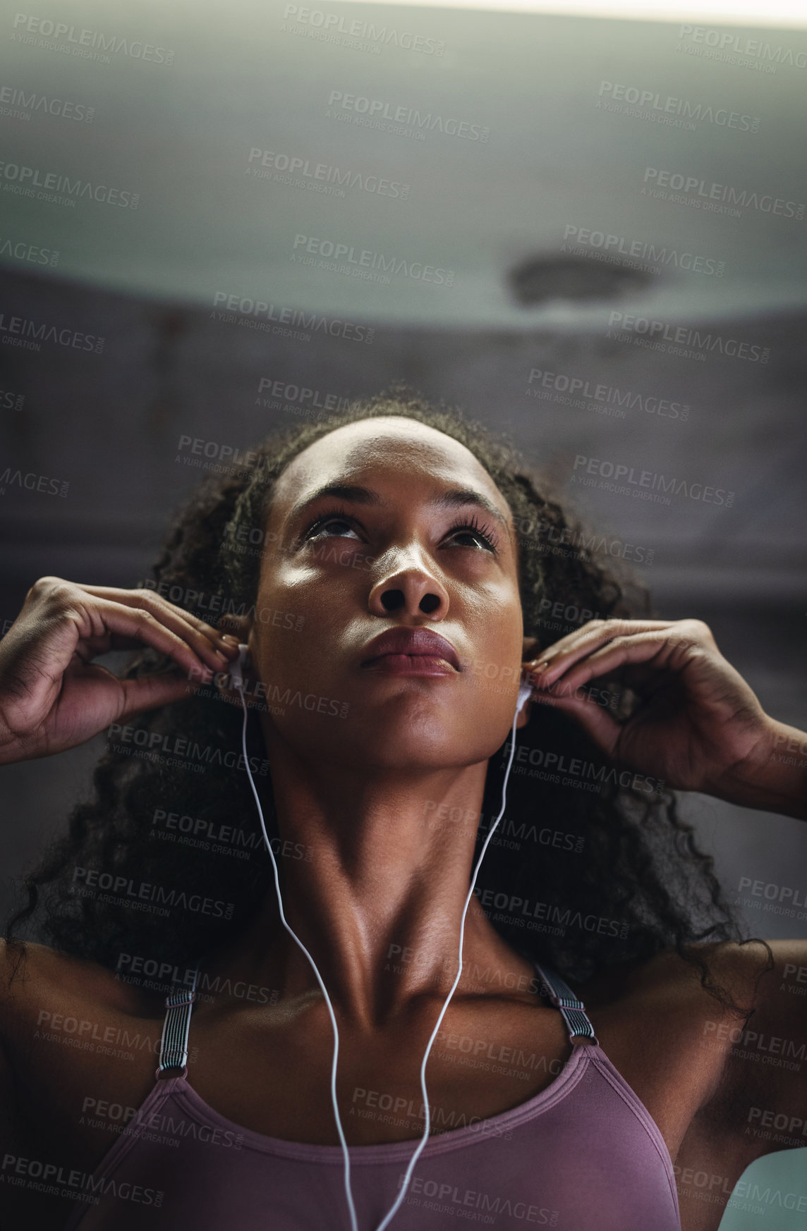 Buy stock photo Shot of an attractive young sportswoman listening to music while exercising indoors