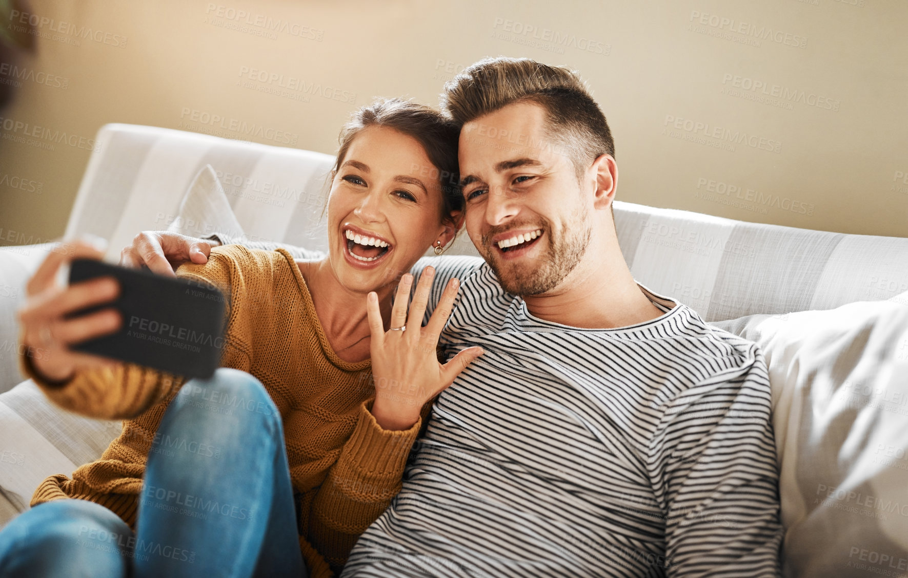 Buy stock photo Shot of a couple announcing their engagement while on a video call
