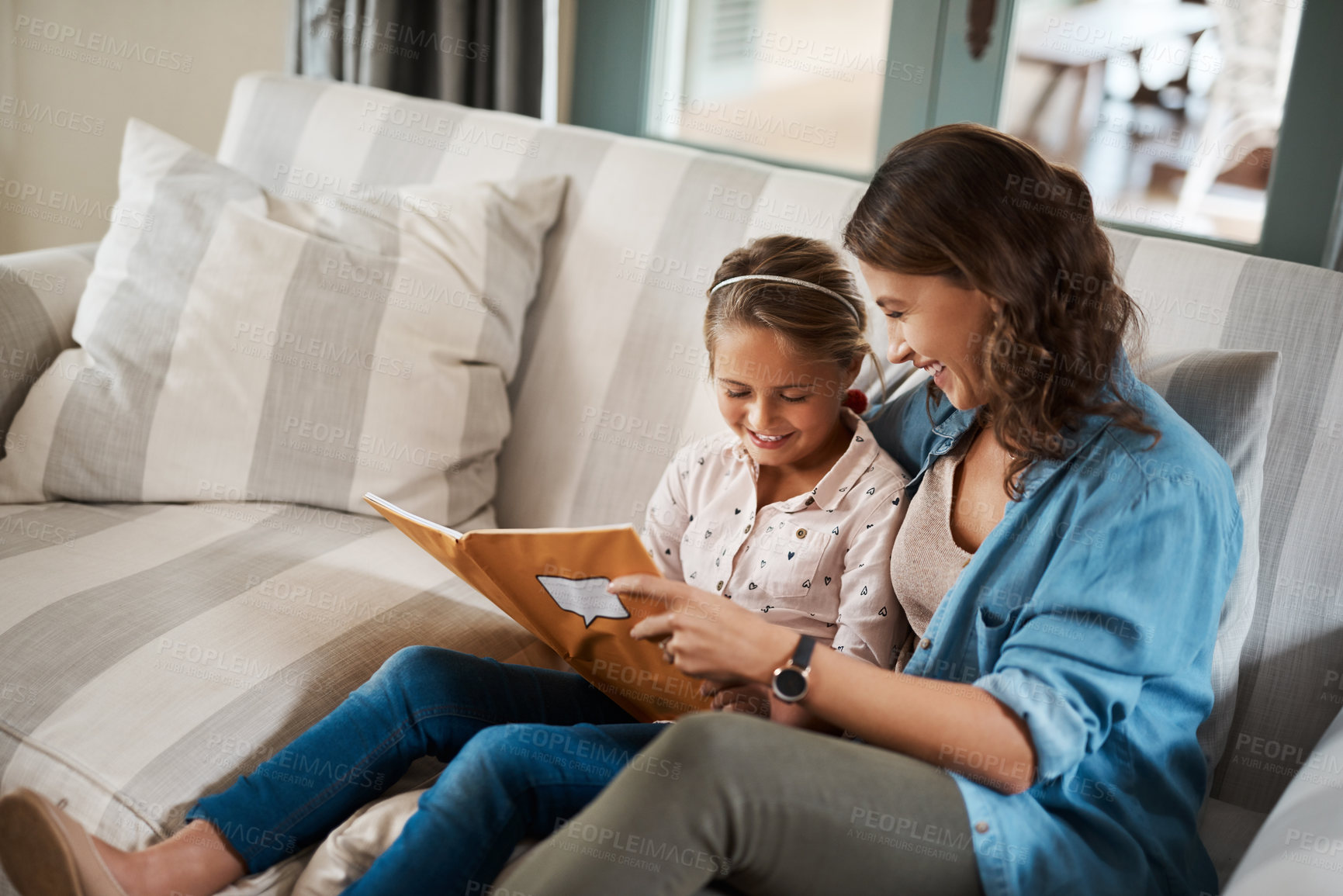 Buy stock photo Shot of a young woman helping her adorable daughter with her homework at home