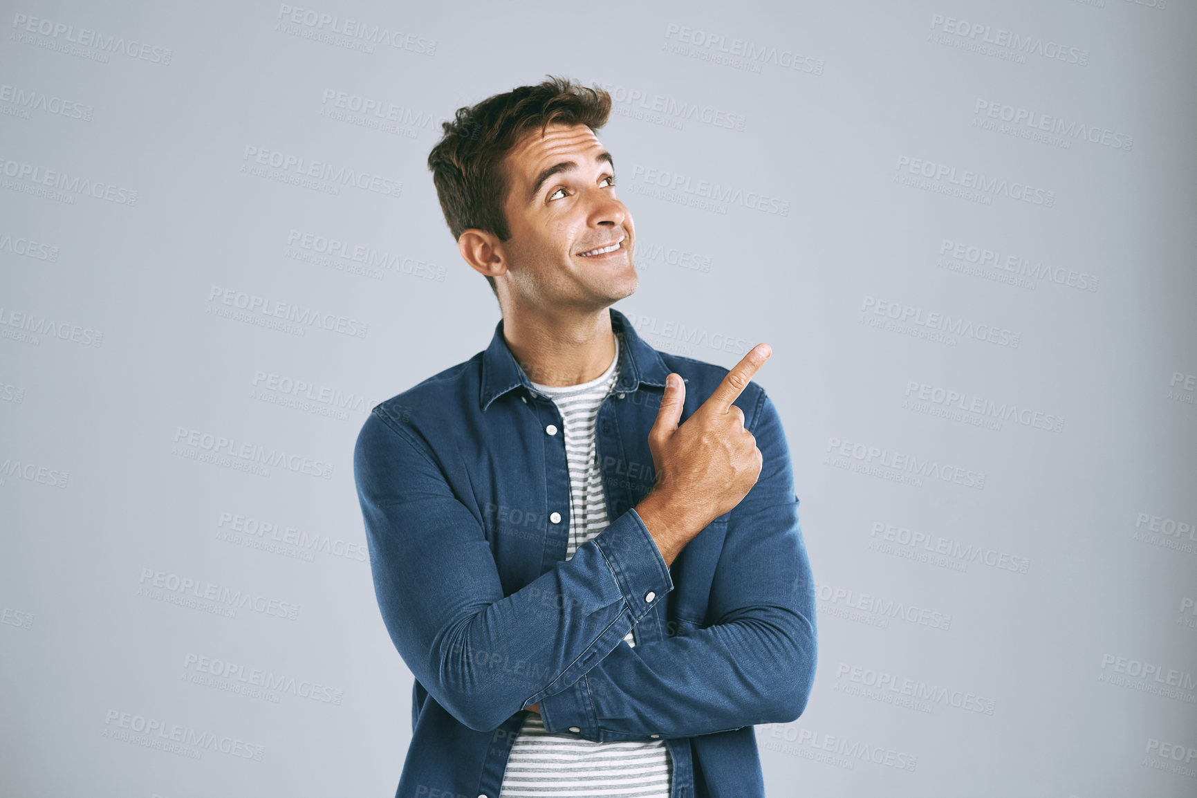 Buy stock photo Cropped shot of a man pointing up against a grey background