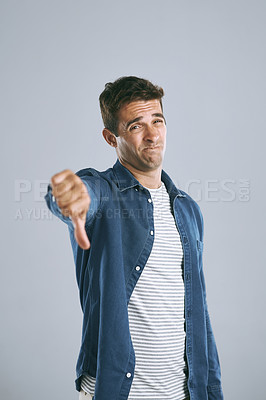 Buy stock photo Cropped shot of a handsome man showing thumbs down