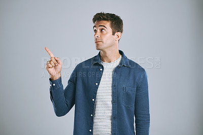 Buy stock photo Cropped shot of a man pointing up against a grey background
