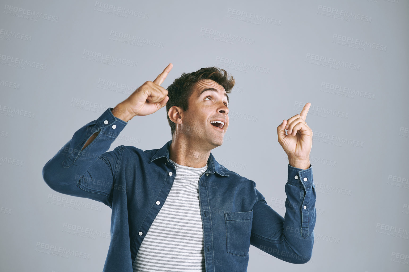 Buy stock photo Happy, pointing up and man with review, opportunity and model on grey studio background. Smile, person and guy with hand gesture, mockup space and promotion with announcement, options and coming soon