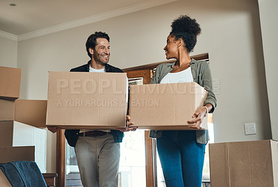 Buy stock photo Happy couple or new home owners moving in together, carrying boxes of furniture or belongings and property. Loving, interracial partners after the purchase of real estate, smiling at each other.