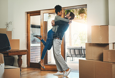 Buy stock photo Joyful interracial couple moving in to a new home together hugging feeling happy and excited. Diverse, loving and young lovers relocating to a house and celebrating by embracing 
