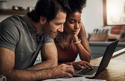 Buy stock photo Couple, finance and laptop in a kitchen for planning, budget and savings or paying bills together in their home. Interracial marriage, online and people with tax, mortgage or home loan or insurance