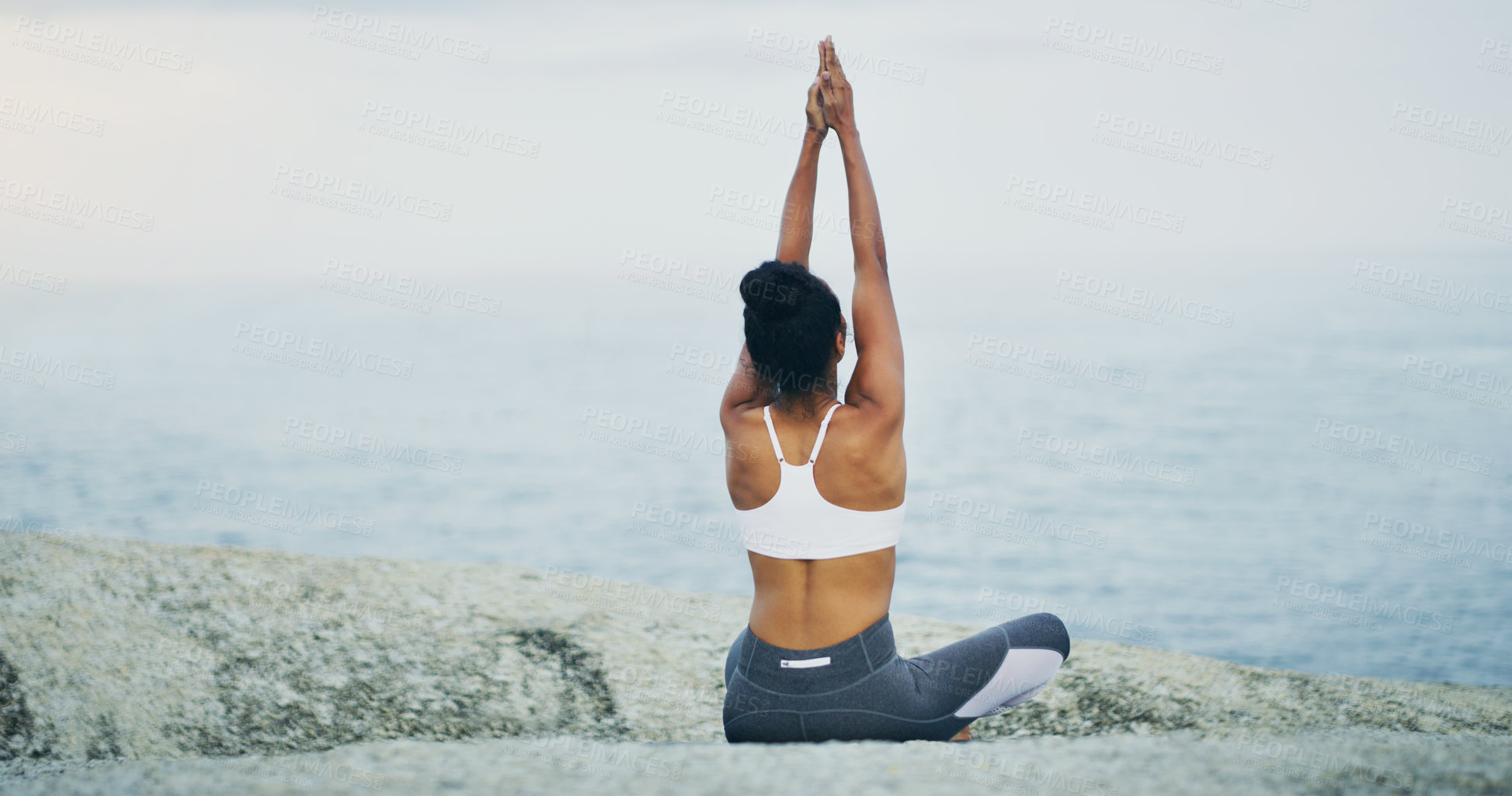 Buy stock photo Beach, yoga or woman stretching arms in lotus meditation for peace or mindfulness in outdoor nature to relax. Chakra, calm or back of girl on rock at sea or ocean for awareness or balance in pilates