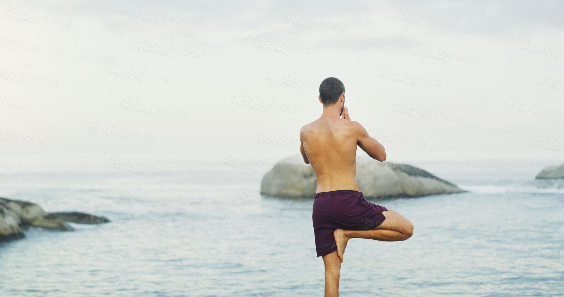 Buy stock photo Man, yoga and tree pose for balance at sea or wellness peace for vrksasana, rear view or mindfulness. Male person, chakra and zen exercise at ocean or holistic resort or spirituality, healing or calm