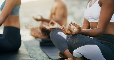 Buy stock photo Cropped shot of an unrecognizable group of people sitting and meditating together while on the beach during an overcast day