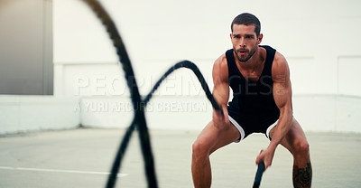 Buy stock photo Man, fitness and battle ropes in training, exercise or workout for physical wellness outdoors. Fit, active and serious male person exercising with rope for intense body endurance, stamina or cardio