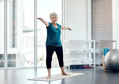 Buy stock photo Shot of a senior woman practising yoga in a studio