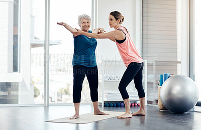 Buy stock photo Shot of a fitness instructor helping a senior woman during a yoga class