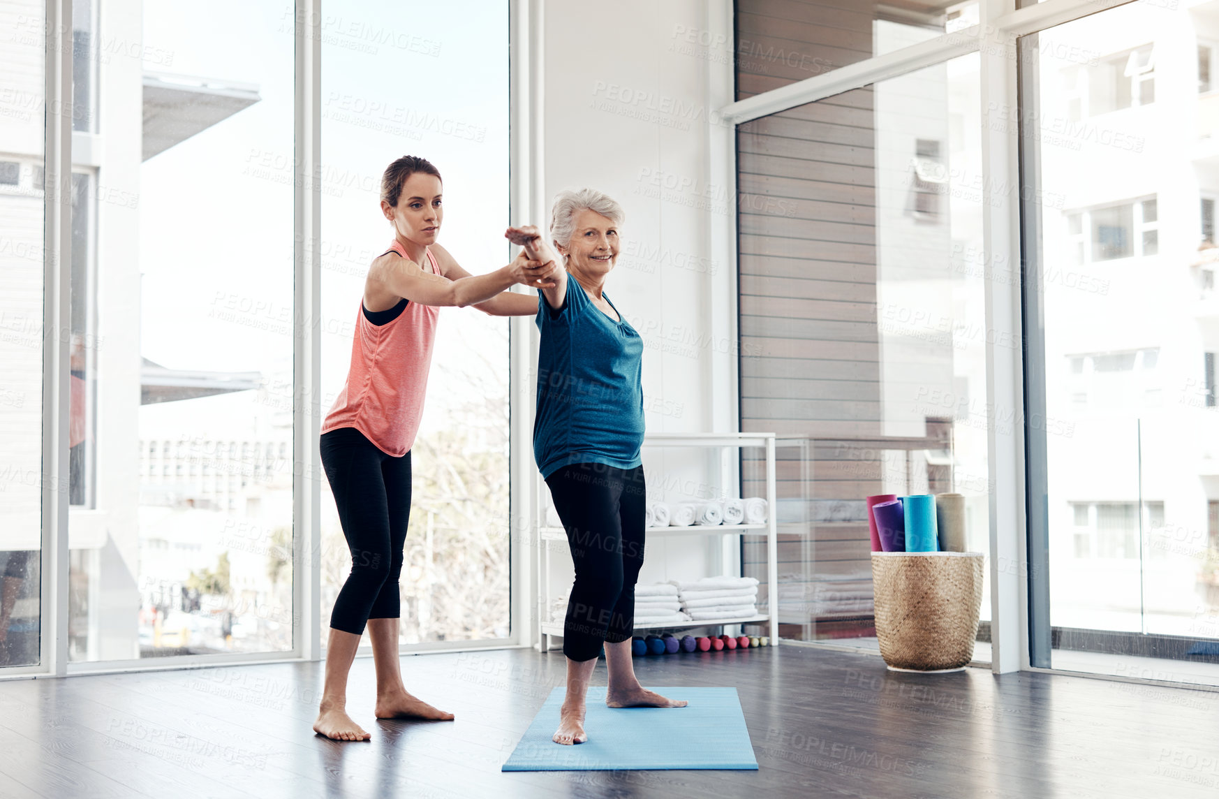 Buy stock photo Shot of a fitness instructor helping a senior woman during a yoga class