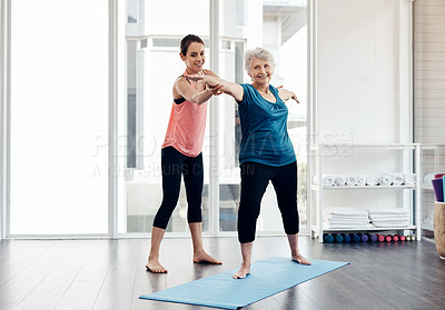 Buy stock photo Shot of a fitness instructor helping a senior woman during a yoga class