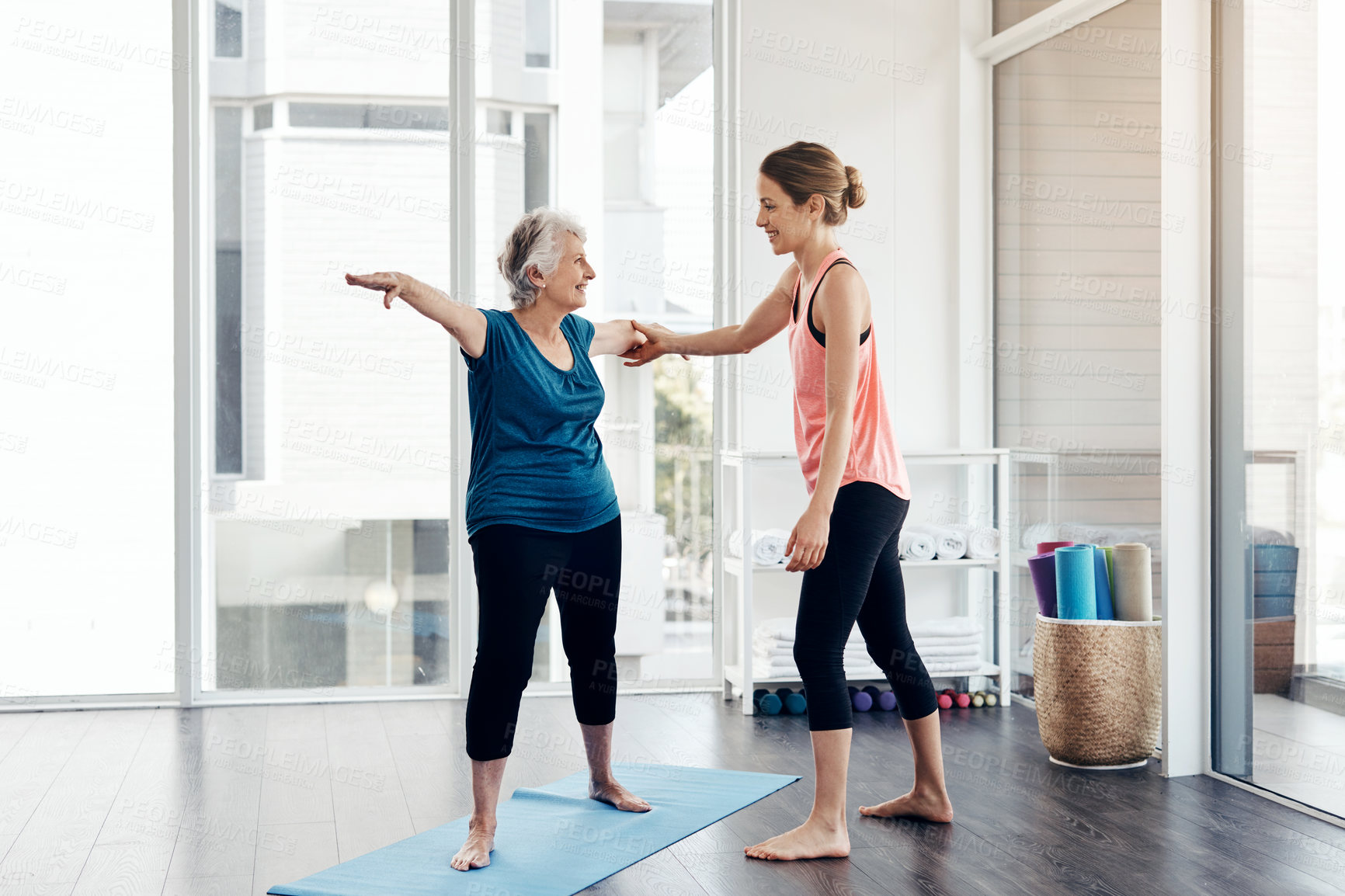 Buy stock photo Shot of a fitness instructor helping a senior woman during a yoga class