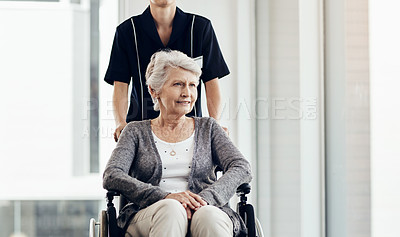 Buy stock photo Shot of a senior woman in a wheelchair being pushed by a female nurse
