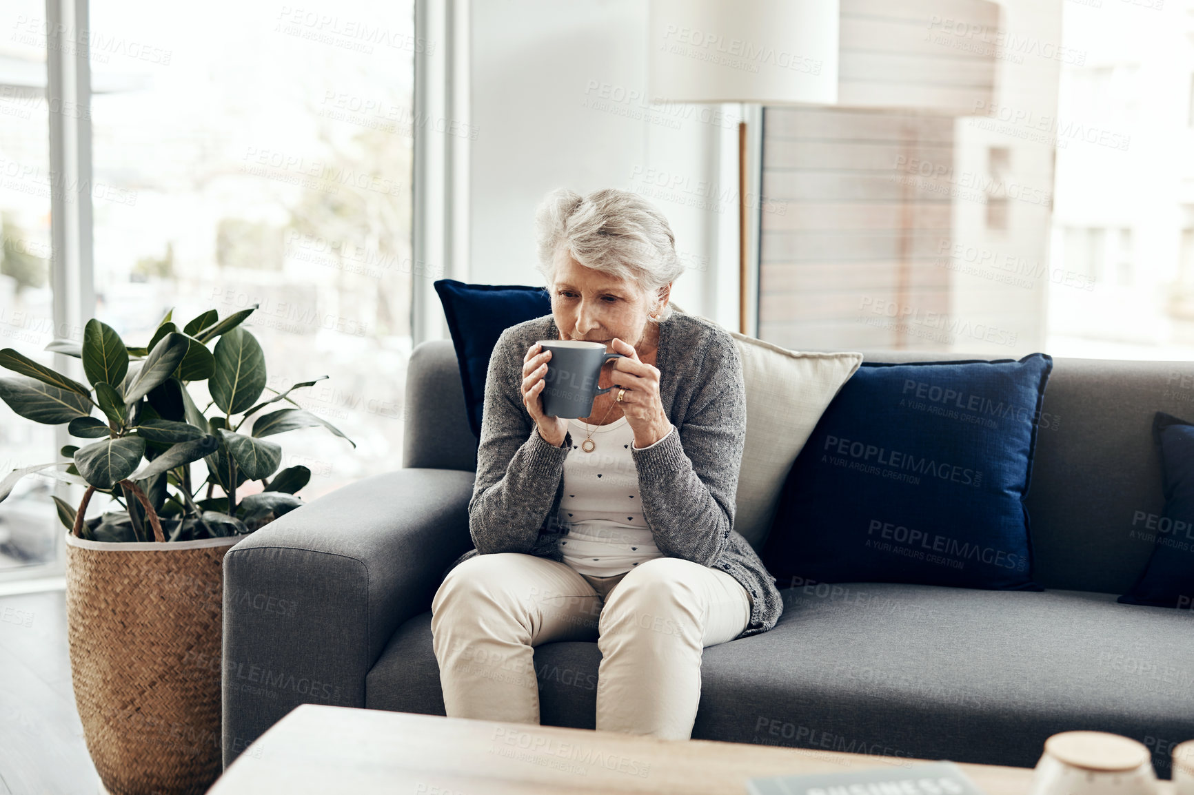 Buy stock photo Relax, drinking coffee and senior woman on sofa with cup for peace, retirement or morning routine in living room. Calm, weekend and elderly person with herbal tea, caffeine or hot beverage in home