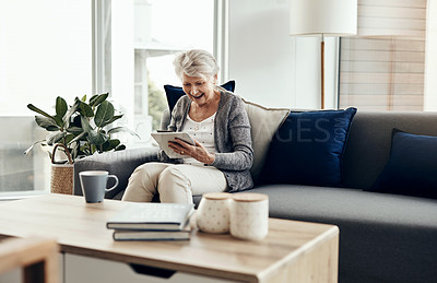 Buy stock photo Shot of a senior woman holding her credit card while browsing on a digital tablet