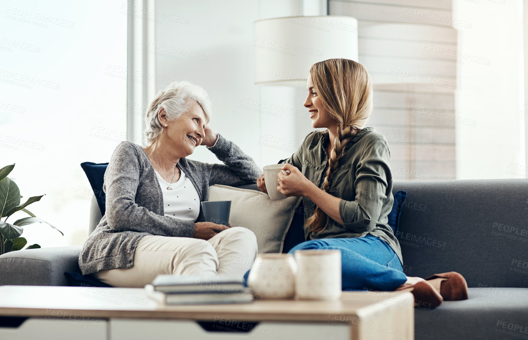 Buy stock photo Cropped shot of a senior woman and her adult daughter sitting together at home
