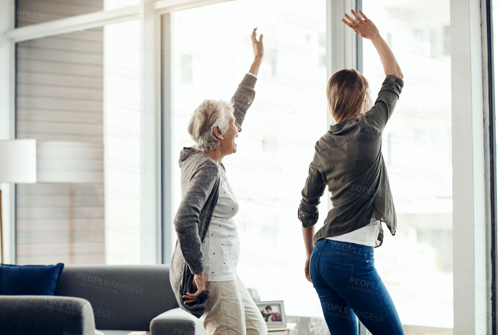 Buy stock photo Shot of a senior woman and her adult daughter dancing together at home