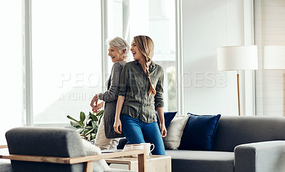 Buy stock photo Shot of a senior woman and her adult daughter dancing together at home