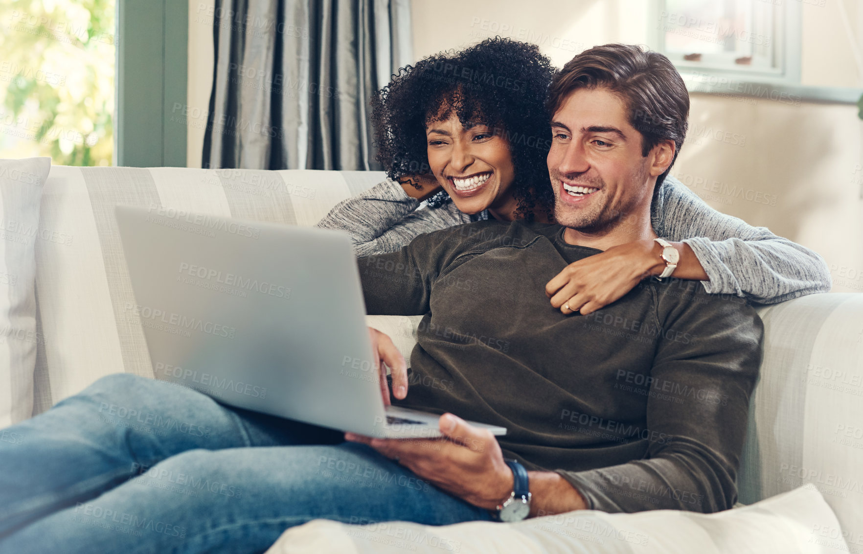 Buy stock photo Couple, bonding and laptop with streaming, watching movie and happy in lounge, sofa and home on break. Woman, man and technology as interracial partner in together, cheerful and embrace in connection